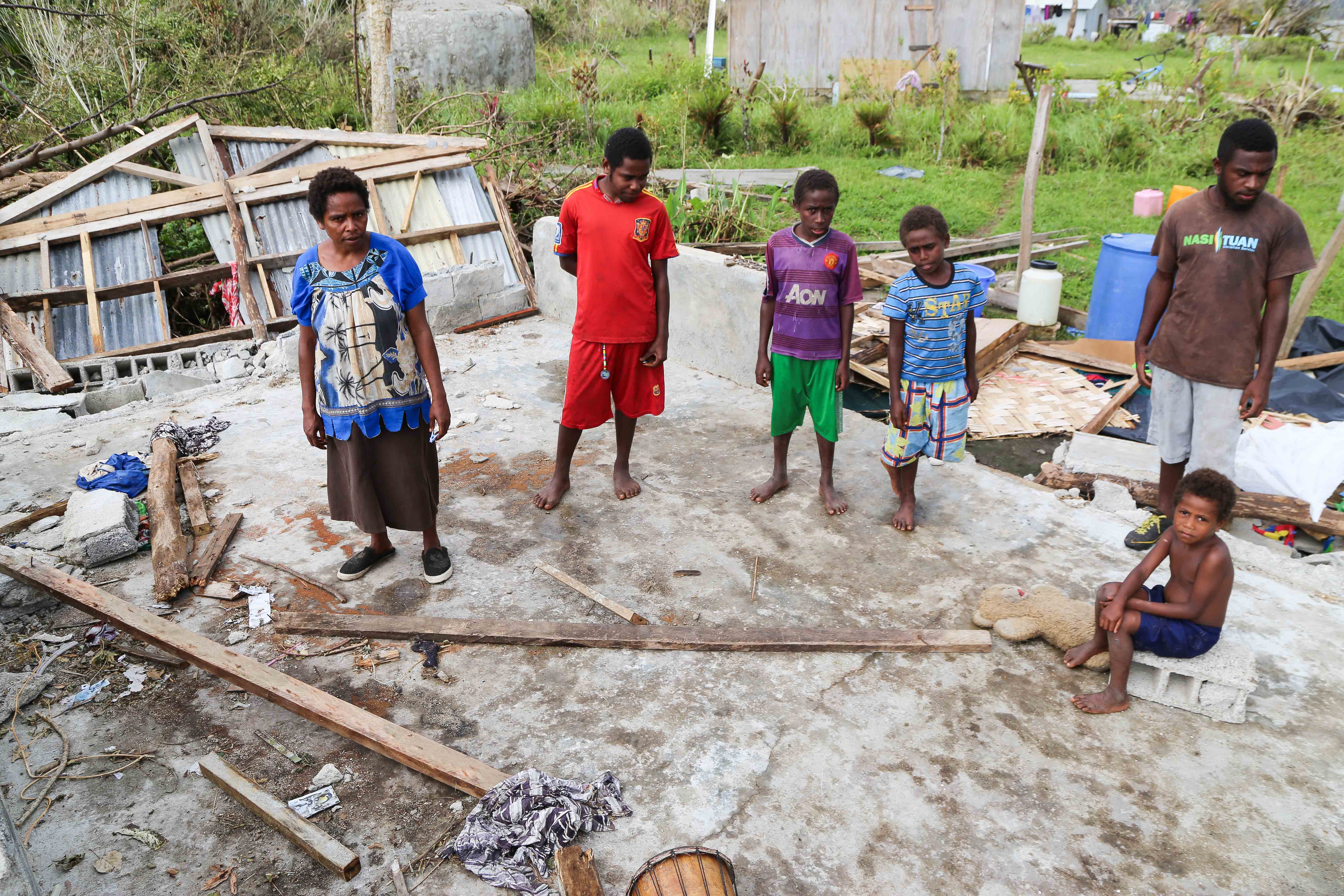 May Isaiah and her family stand amidst the rubble of what used to be their home